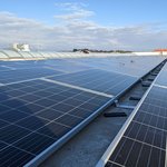 Viele Solaranlagen (Photovoltaik) Panele mit Sonnenschein auf dem Firmendach von Lebosol und Semfill