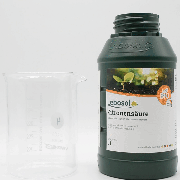 Eine Flasche Lebosol®-Zitronensäure wird in ein Becherglas ausgegossen. 