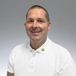 Portrait von Friedrich Roth in weißem Polo Shirt mit Lebosol® Blättchen vor grauem Hintergrund.