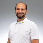 Mann mit Bart in wei&szlig;em Poloshirt und Lebosol-Logo Stick am Kragen vor wei&szlig;-grauem Hintergrund.
