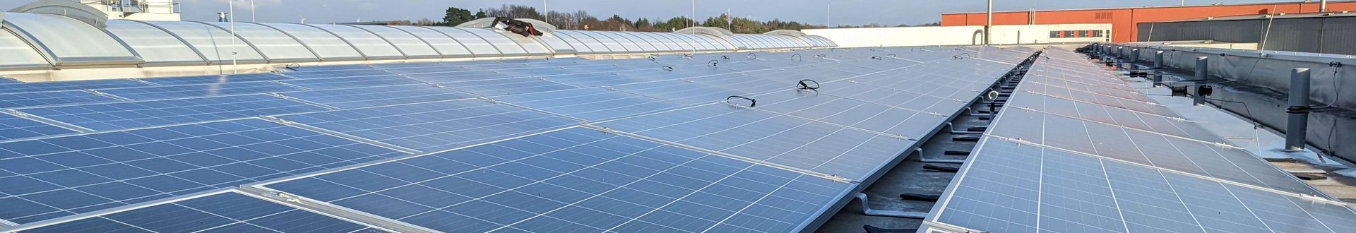 Viele Solaranlagen (Photovoltaik) Panele mit Sonnenschein auf dem Firmendach von Lebosol und Semfill