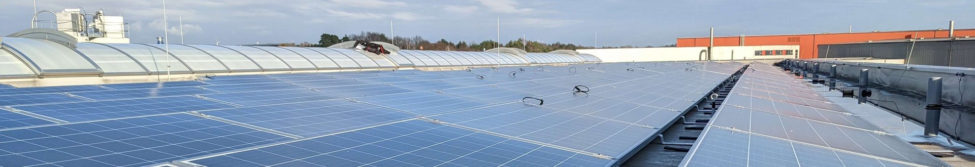 Viele Solaranlagen (Photovoltaik) Panele mit Sonnenschein auf dem Firmendach von Lebosol und Semfill