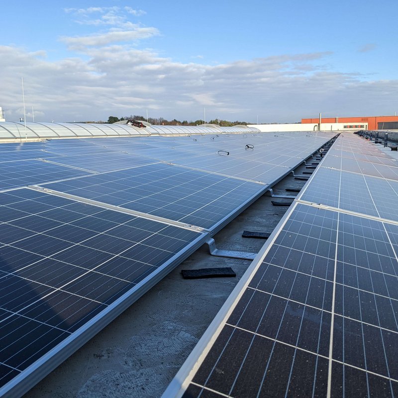 Viele Solaranlagen (Photovoltaik) Panele mit Sonnenschein auf dem Firmendach von Lebosol und Semfill