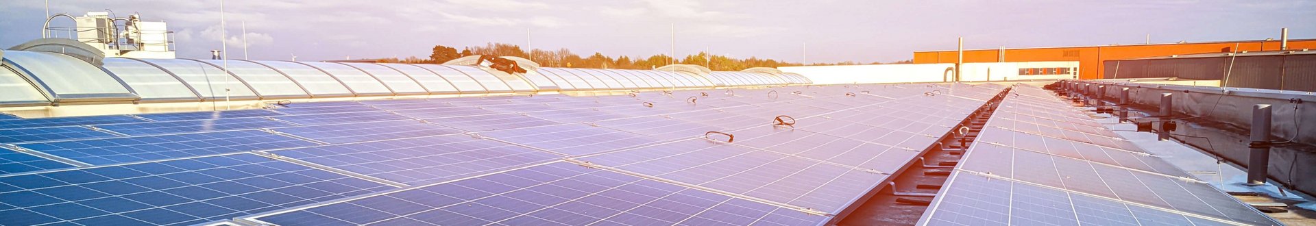 Viele Solaranlagen (Photovoltaik) Panele mit Sonnenschein auf dem Firmendach von Lebosol und Semfill