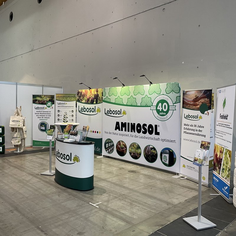 Große Messehalle mit Lebosol®-Stand bestehende aus einer Theke, Roll-Ups, Aufstellwand und vielem mehr in Lebosol®-Optik