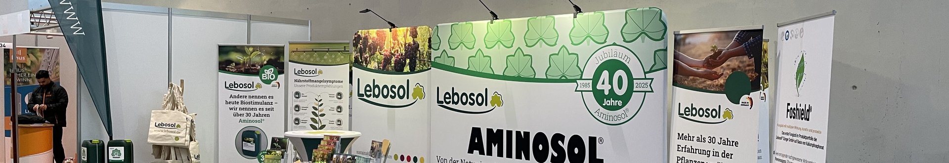 Große Messehalle mit Lebosol®-Stand bestehende aus einer Theke, Roll-Ups, Aufstellwand und vielem mehr in Lebosol®-Optik