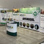 Große Messehalle mit Lebosol®-Stand bestehende aus einer Theke, Roll-Ups, Aufstellwand und vielem mehr in Lebosol®-Optik