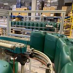 Grüne 10 Liter Kanister von Lebosol laufen in einer Produktionshalle über ein Fließband.