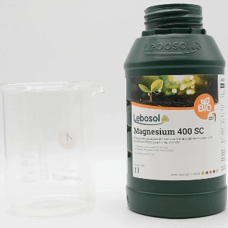 Eine Flasche Lebosol®-Magnesium 400 SC wird in ein Becherglas ausgegossen. 